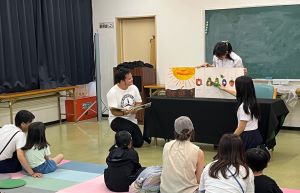 はらぺこあおむしの人形を使って大型絵本を読み聞かせする様子