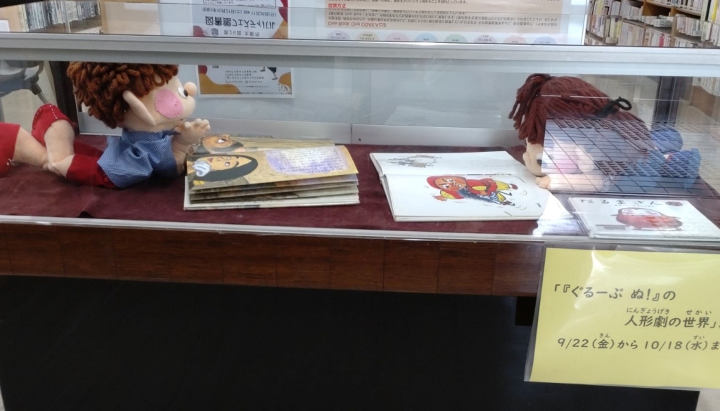 人形たちが絵本を読んでいる写真
