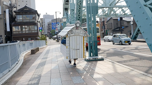 家をせおって歩いている写真